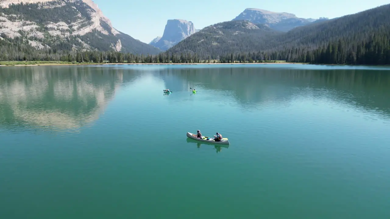 People On Canoe Boats Floating On Still Water Of Green River Lakes In Wyoming