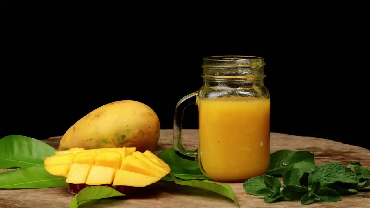 stop motion mango juice smoothie in glass jar black background