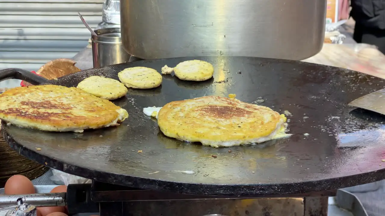 Some Newari bara frying on a skillet at a local market in Nepal