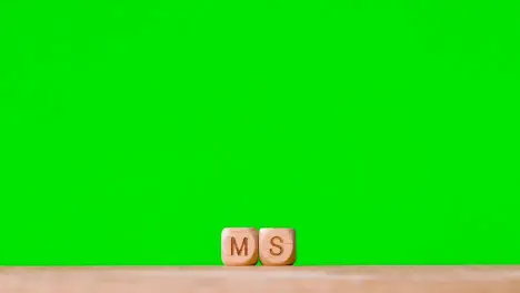 Medical Concept With Wooden Letter Cubes Or Dice Spelling MS Against Green Screen