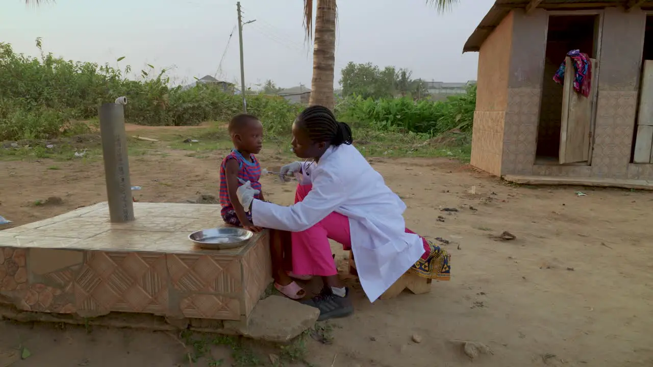 Black women doctor in the Africa giving the vaccination shot to a young child