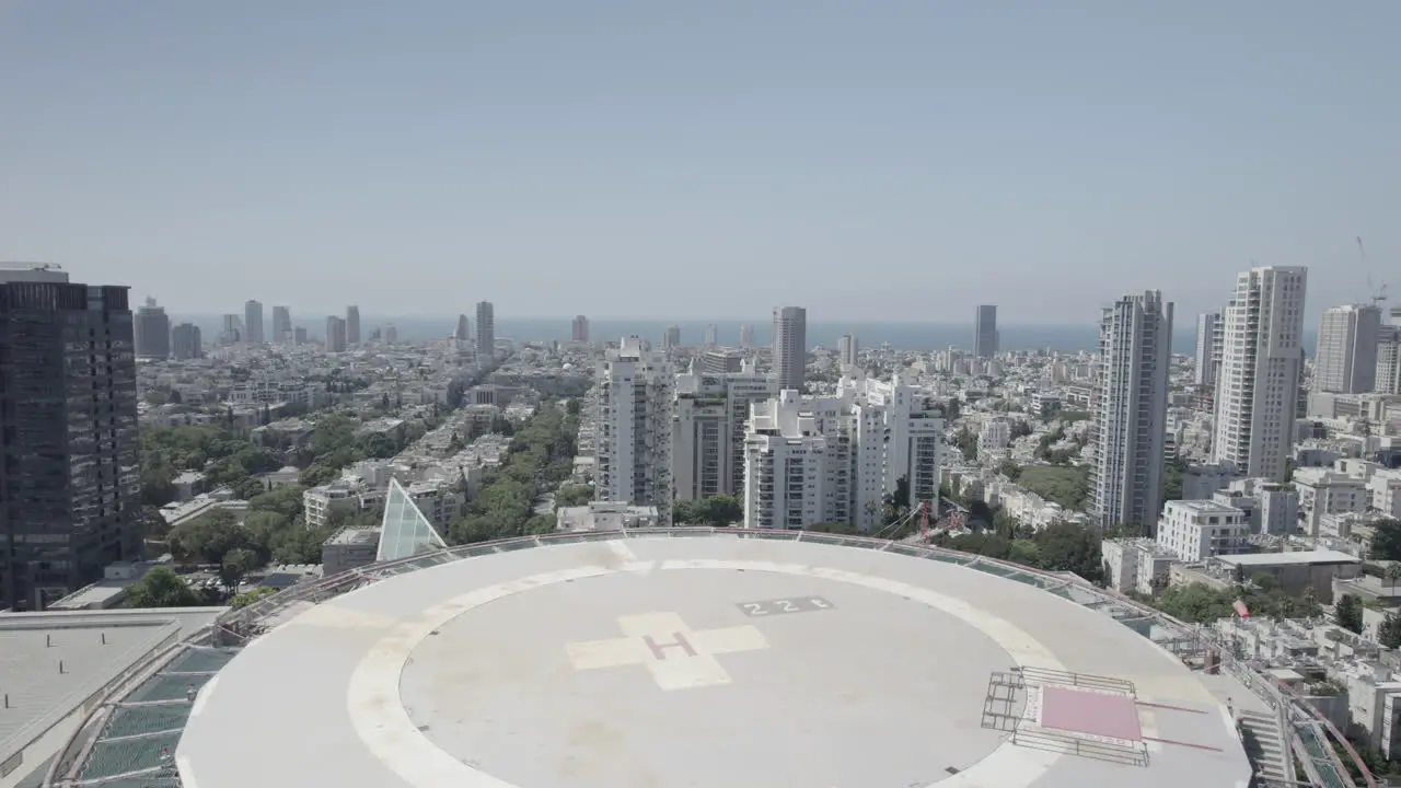 Flying over the helicopter Landing Pad on the roof of the Hospitalization tower building at the Ichilov Hospital Center Tel Aviv the mediterranean sea in the background push in shot