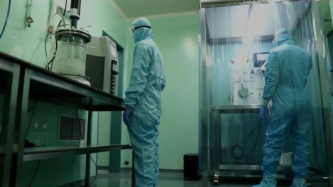 Laboratory Specialists In Full PPE Checking Microbial Fermenter