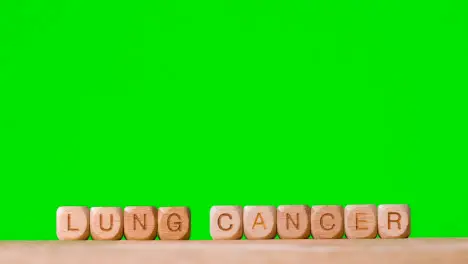 Medical Concept With Wooden Letter Cubes Or Dice Spelling Lung Cancer Against Green Screen Background