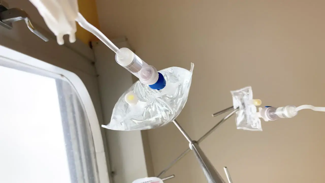 Two intravenous drips hang from their stand administering medication