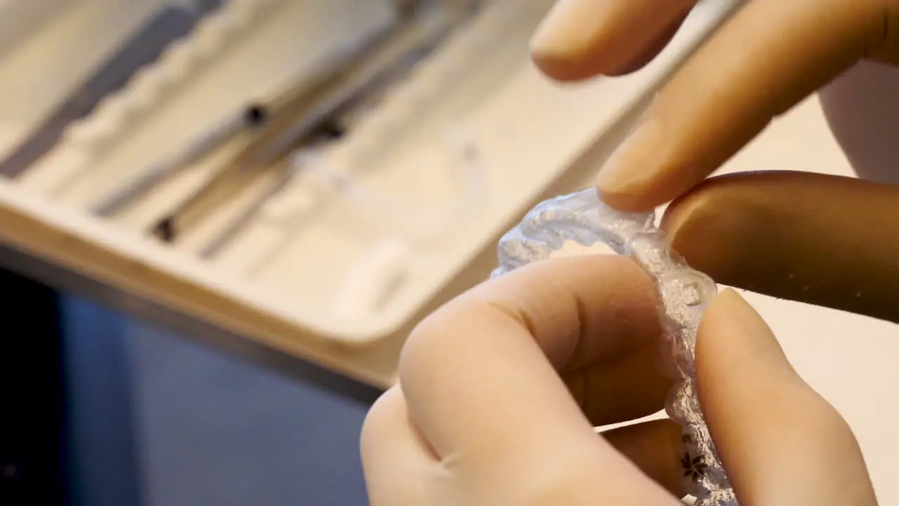 Tight close up of a dentist checking an invisalign retainer