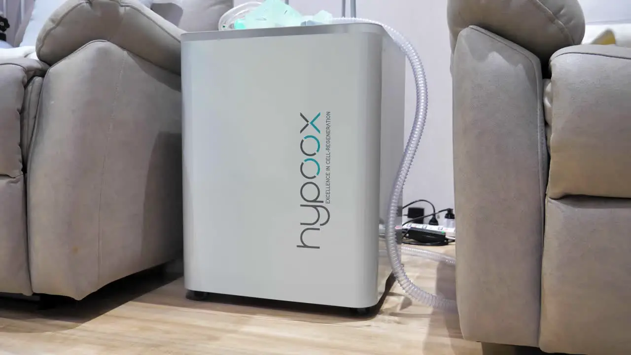 Static shot of an interval-hypoxia-hyperoxia-therapy machine sitting between chairs