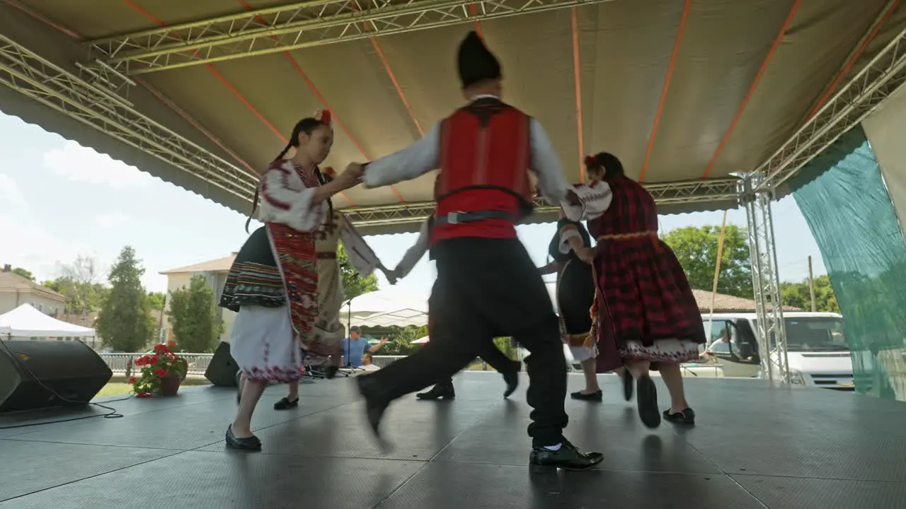 Bulgarian dancers dance and run in circles on cultural festival stage