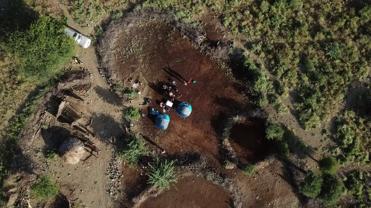 4k aerial view from above of a camp of Kenyans and tourists in a savanna area of the Lake Natron region Kenya East Africa