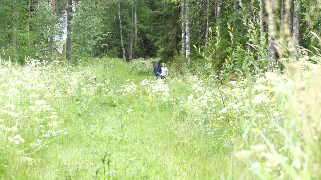 Eight and nine year old boys walking in floral summer meadow SLOW MOTION