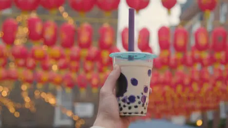 Close Up Of Hand Holding Takeaway Bubble Tea In Chinatown London UK