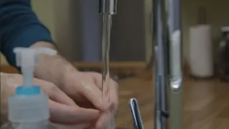 Close Up Shot of Male Hands Washing Hands Running Under Tap 