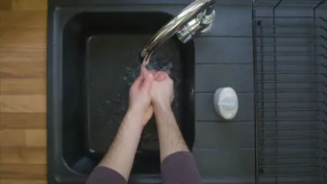 Top Down Shot of Male Hands Turning On Tap and Washing with Soap