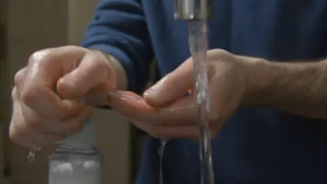 Close Up Shot of Male Hands Washing Under Running Kitchen Tap with Soap