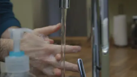 Close Up Shot of Male Hands Washing Hands Running Under Tap with Soap