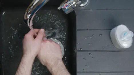 Top Down Shot of Male Hands Turning On Tap and Washing Hands