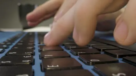 Sliding Extreme Close Up Shot of Pair of Male Hands Typing On a Laptop Keyboard