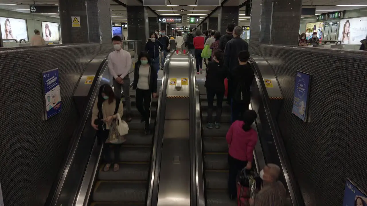 Corona Virus Pandemic Local Commuters using a Hong Kong underground MTR escalator wearing protective face masks