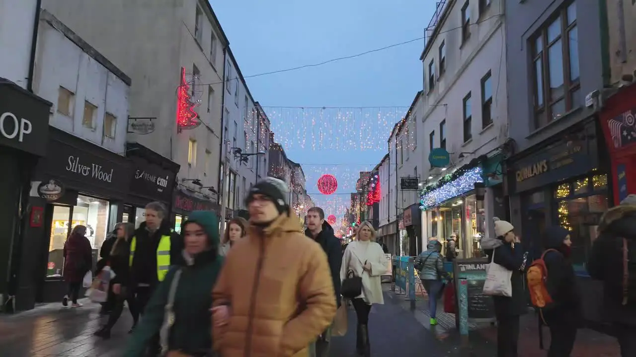 Decorations and street with shops in hyeprlapse during Christmastime in Cork city Ireland