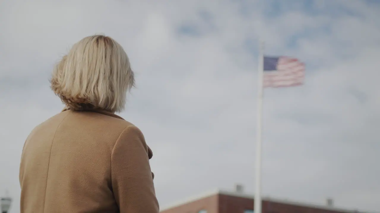 A woman looks at the American flag at the administrative building