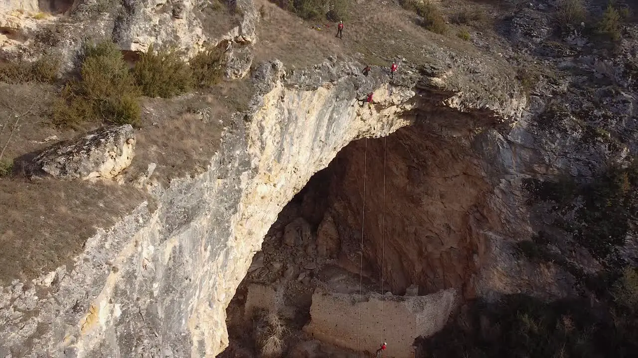 Rescue team hanging on ropes above a massive cave