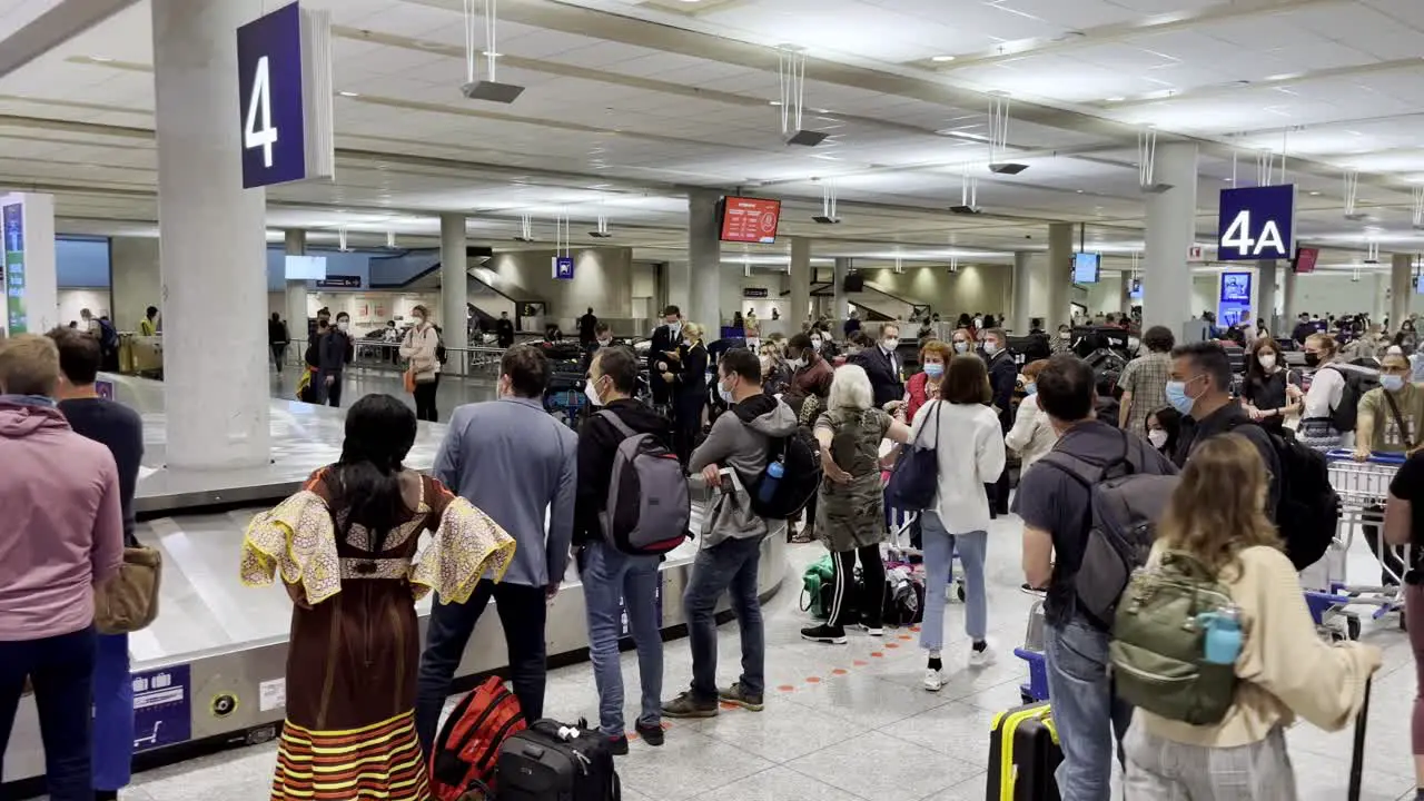 Passengers patiently waiting for their bags at the airport caroussel