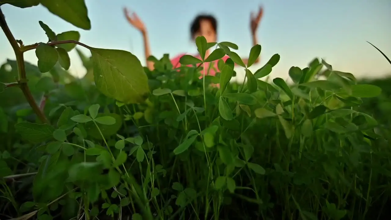 Blurred shot of a young girl doing breathing exercises or yoga in nature and waving her hands background