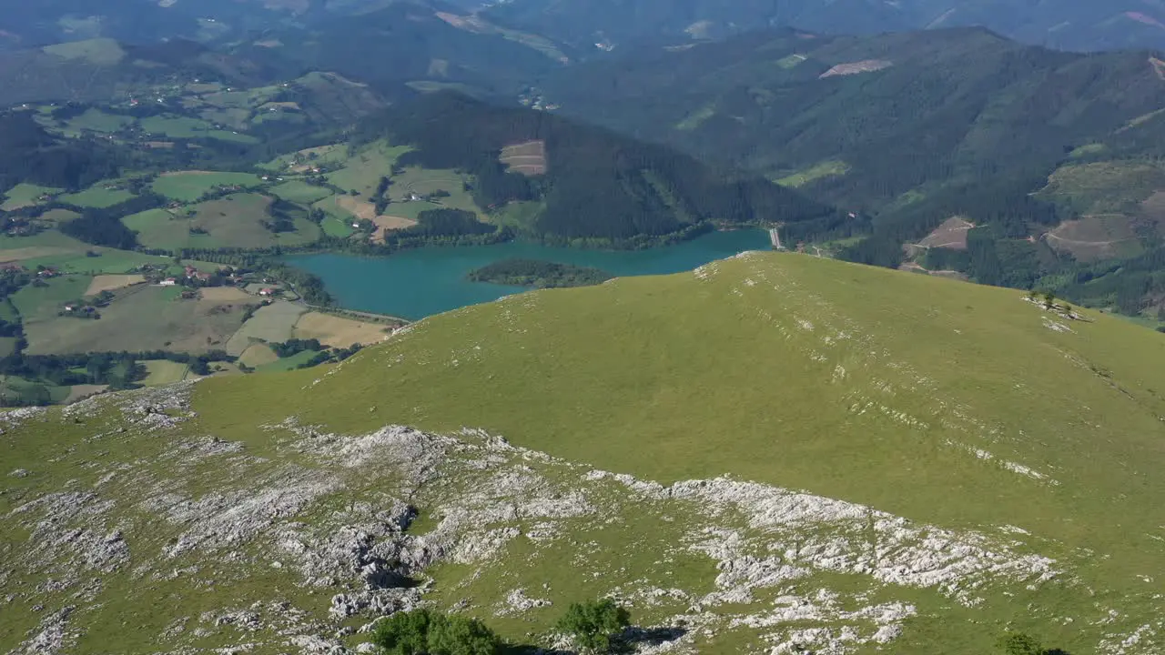 Aerial drone view of the revelation of a lake on top of a mountain in the Basque Country