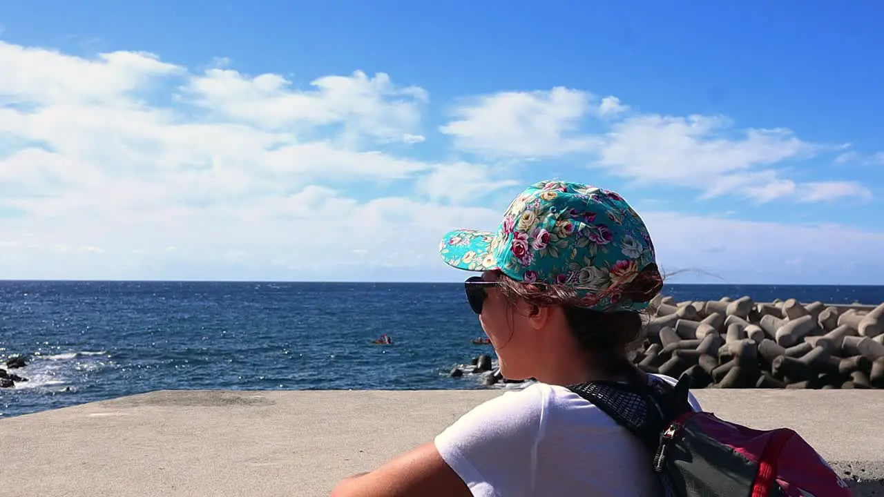 smiling girl enjoys the view of the ocean in front of her