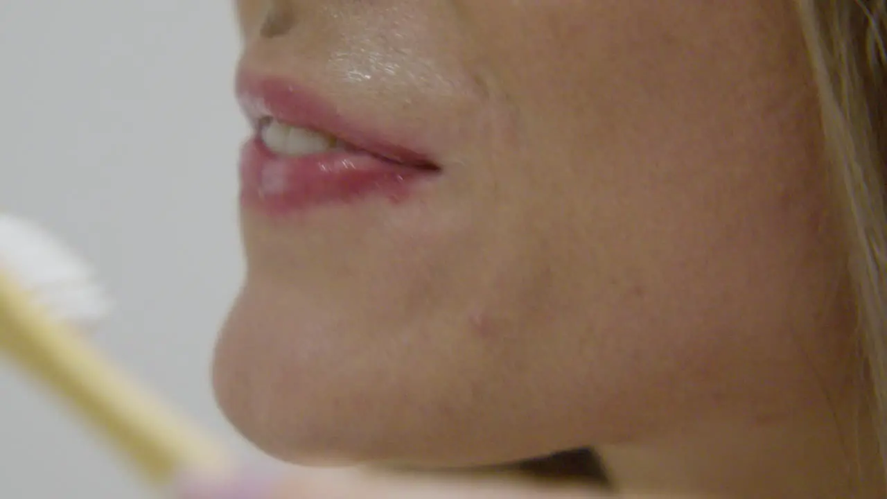 A woman brushing teeth close up