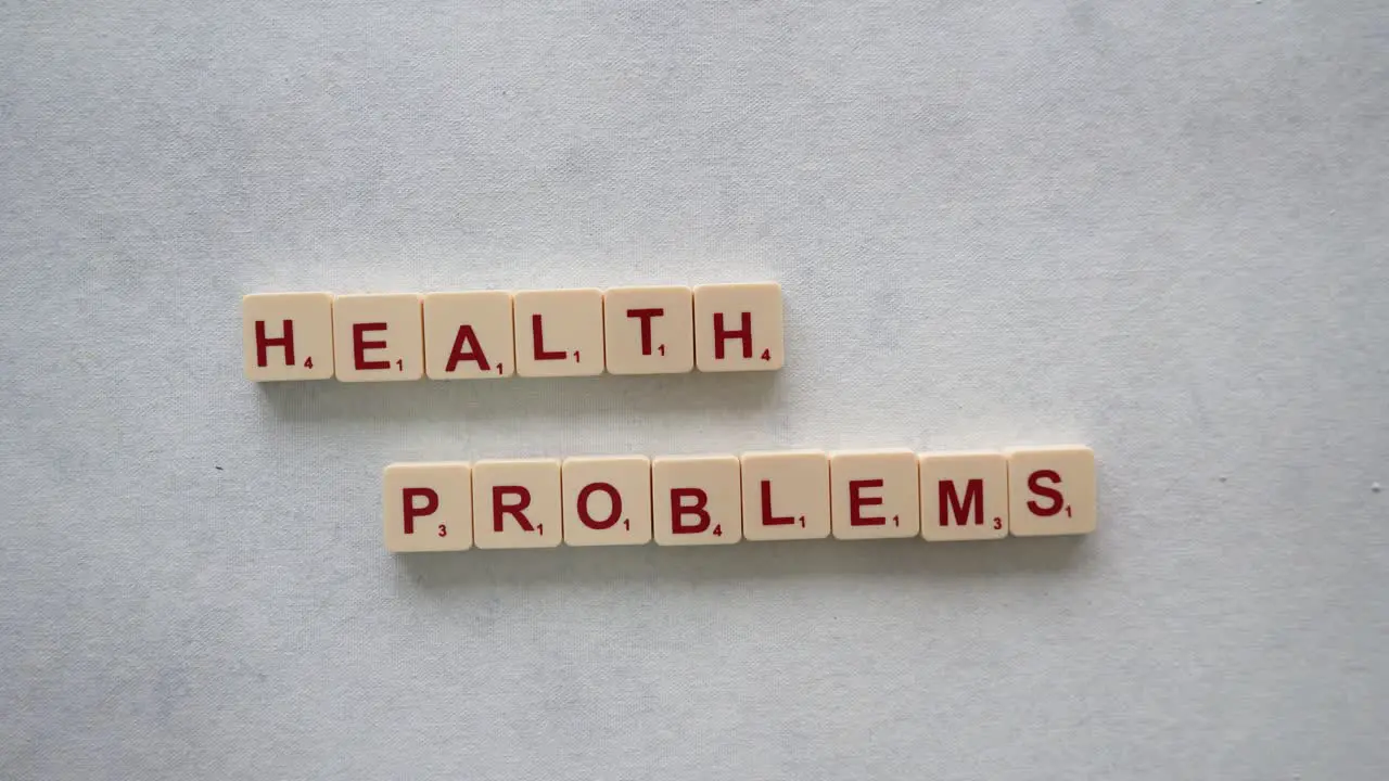 Human hands creating the phrase "health problems" with red letters