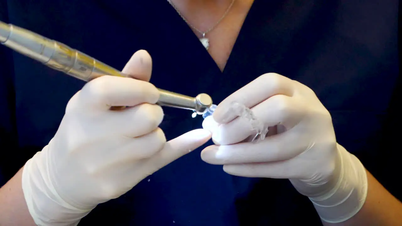 Close up in slowmotion of a dentist checking an invisalign retainer