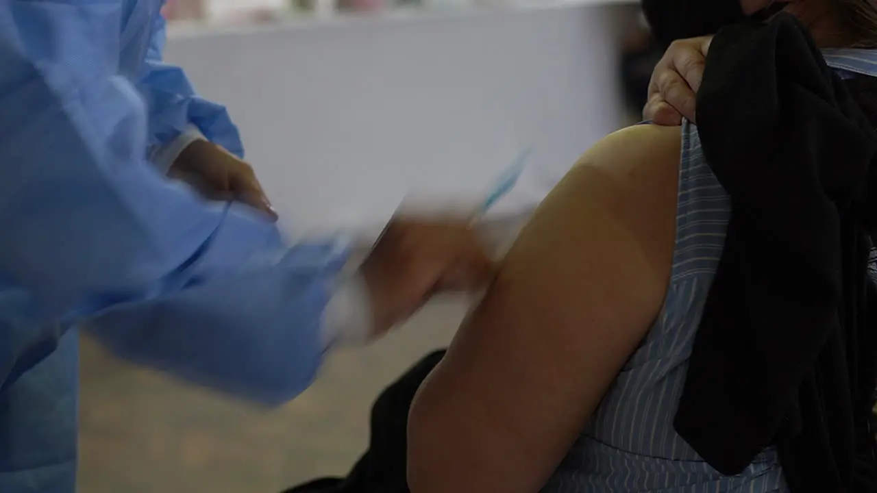 Handheld close up of COVID-19 vaccine applied on a man’s arm