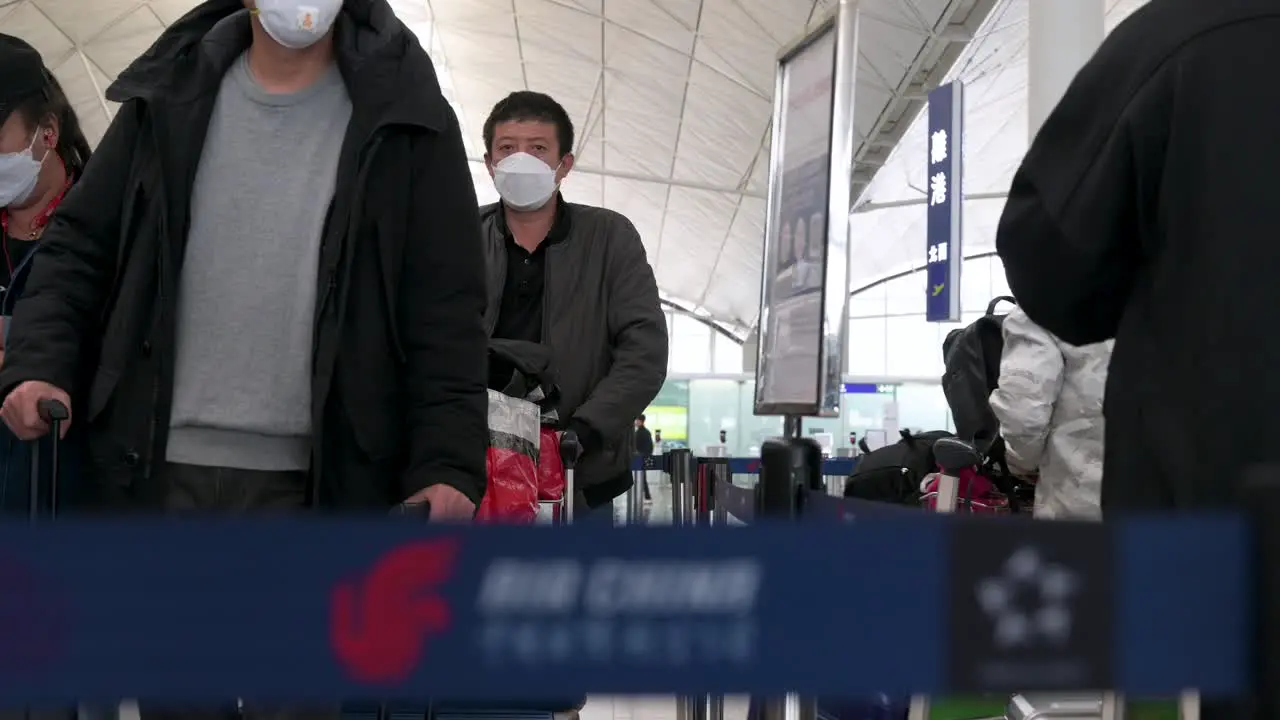 Flight passengers lining up at a Chinese flag carrier Air China airline check-in desk counter at the Chek Lap Kok International Airport in Hong Kong