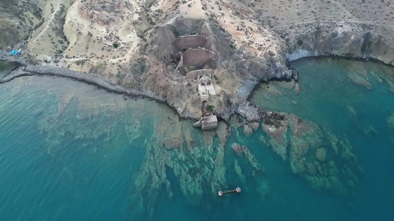 Aerial perspective unveils the abandoned iron mine and deteriorated port now haunting ruins beside the sea