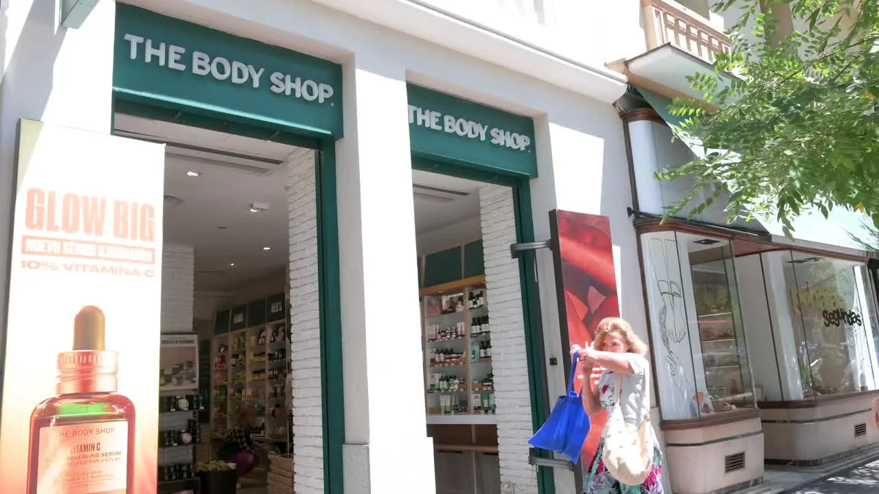 Pedestrians and shoppers walk past the British cosmetics skincare and perfume company The Body Shop in Spain