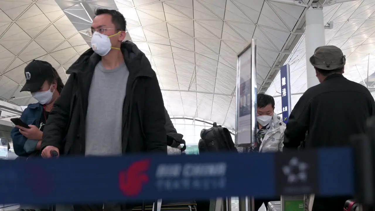 Travel passengers lining up at a Chinese flag carrier Air China airline check-in desk counter at the Chek Lap Kok International Airport in Hong Kong