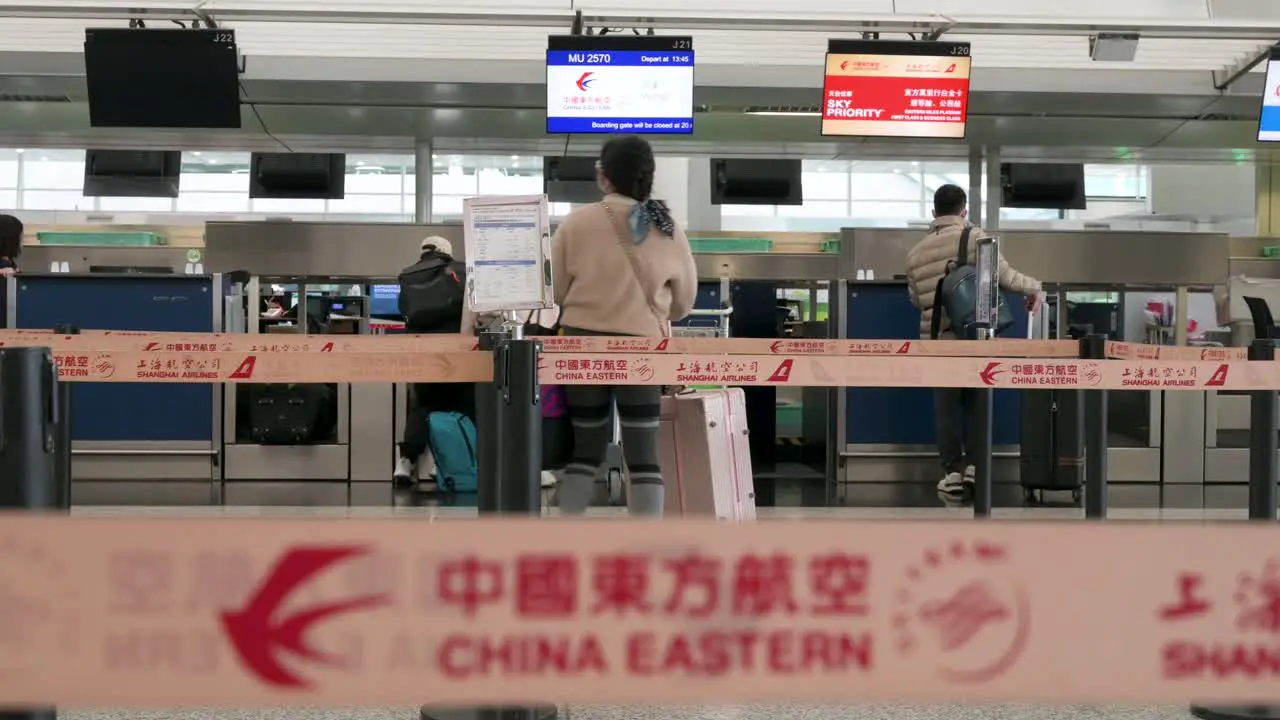 Flight travel passengers check-in at the Chinese flag carrier China Eastern airline desk counter at Chek Lap Kok International Airport in Hong Kong