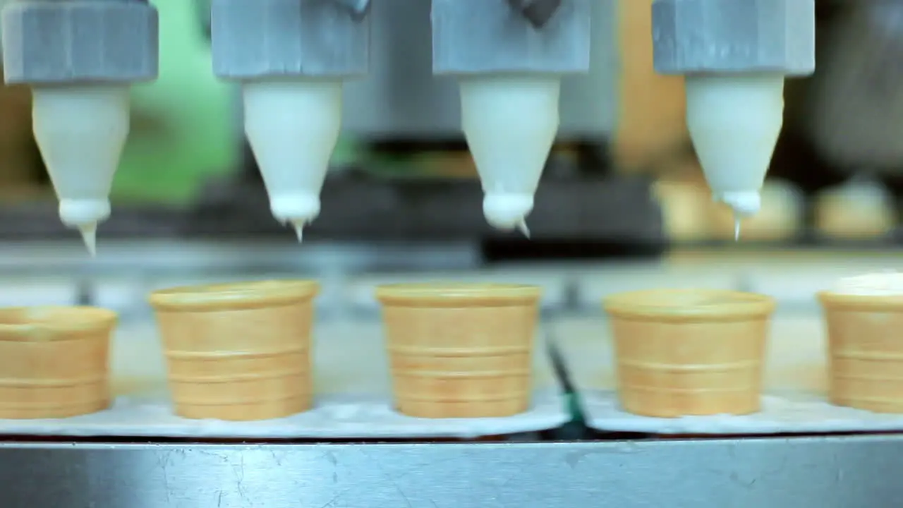 Ice cream pouring in waffle cones Automated production line at food factory