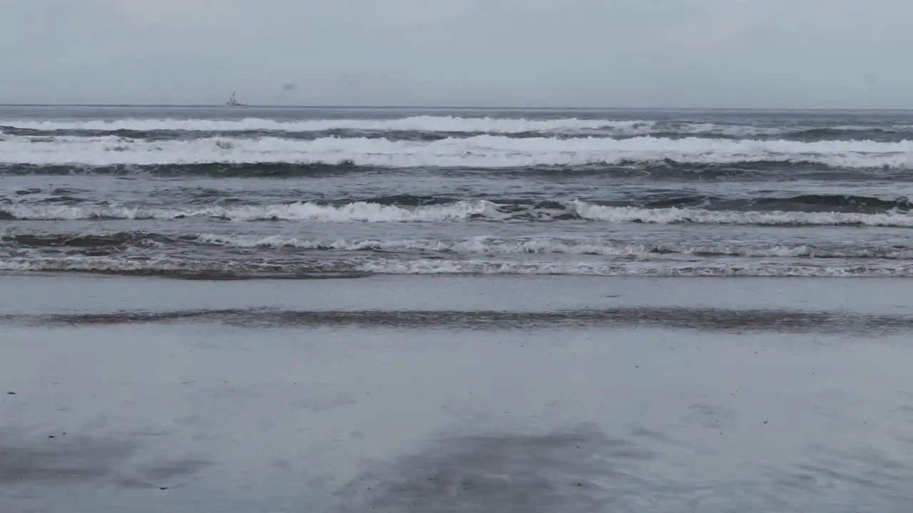 A commercial fishing boat puffing out smoke in the distance on the Pacific Ocean