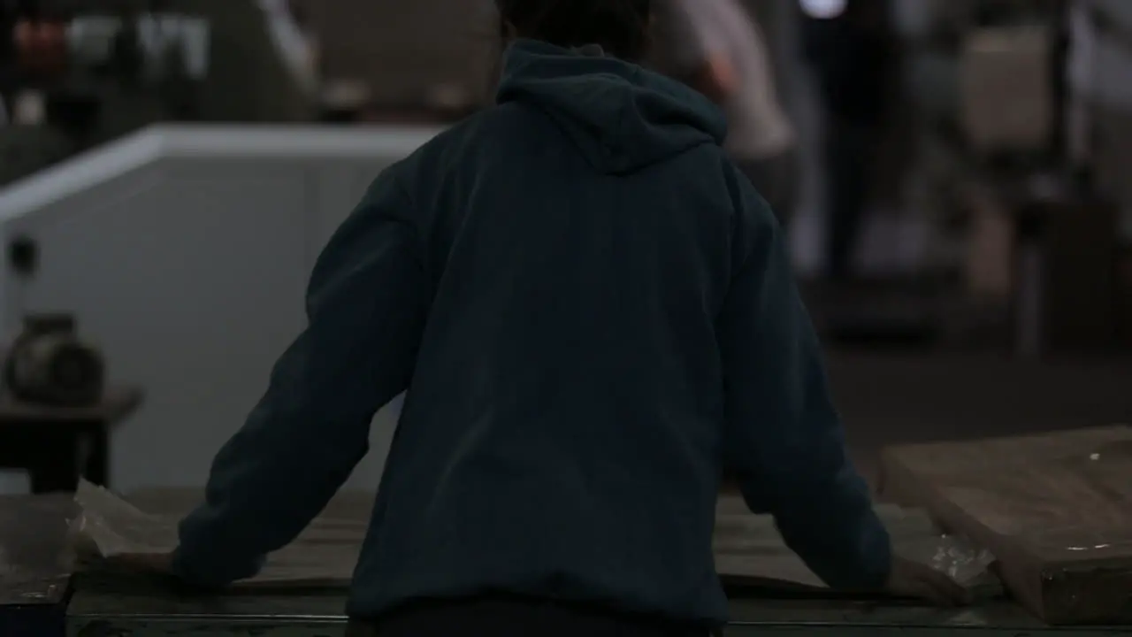 Woman lining plastic bags in a factory floor