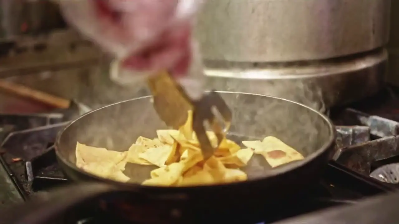 Pouring flipping frying Nachos in a health Vegan Mexican Kitchen