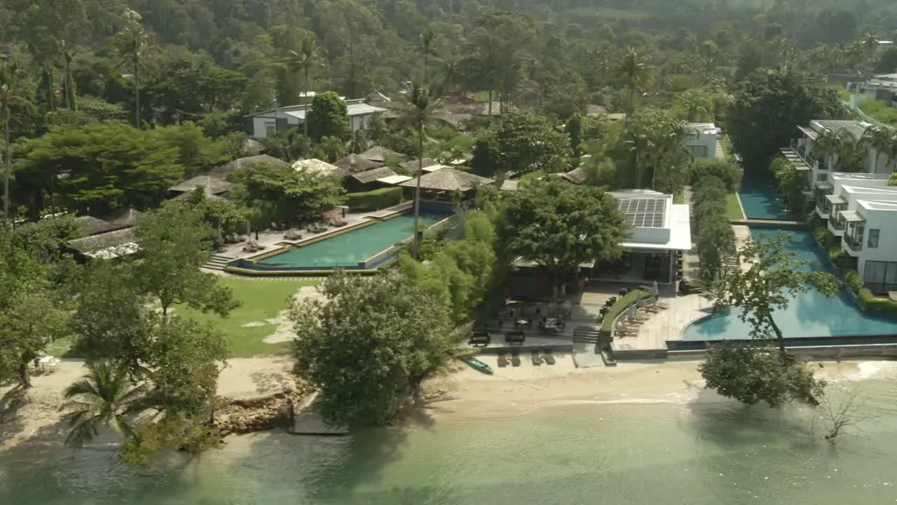 Aerial drone shot low angle of a tropical beach tourist destination in Thailand with no tourists due to travel restrictions and shut downs with empty hotels and empty beaches