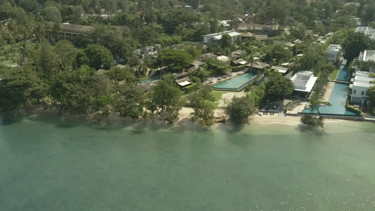 Aerial drone right trucking shot of a tropical beach tourist resorts in Thailand with no tourists due to travel restrictions and shut downs with empty hotels and empty beaches