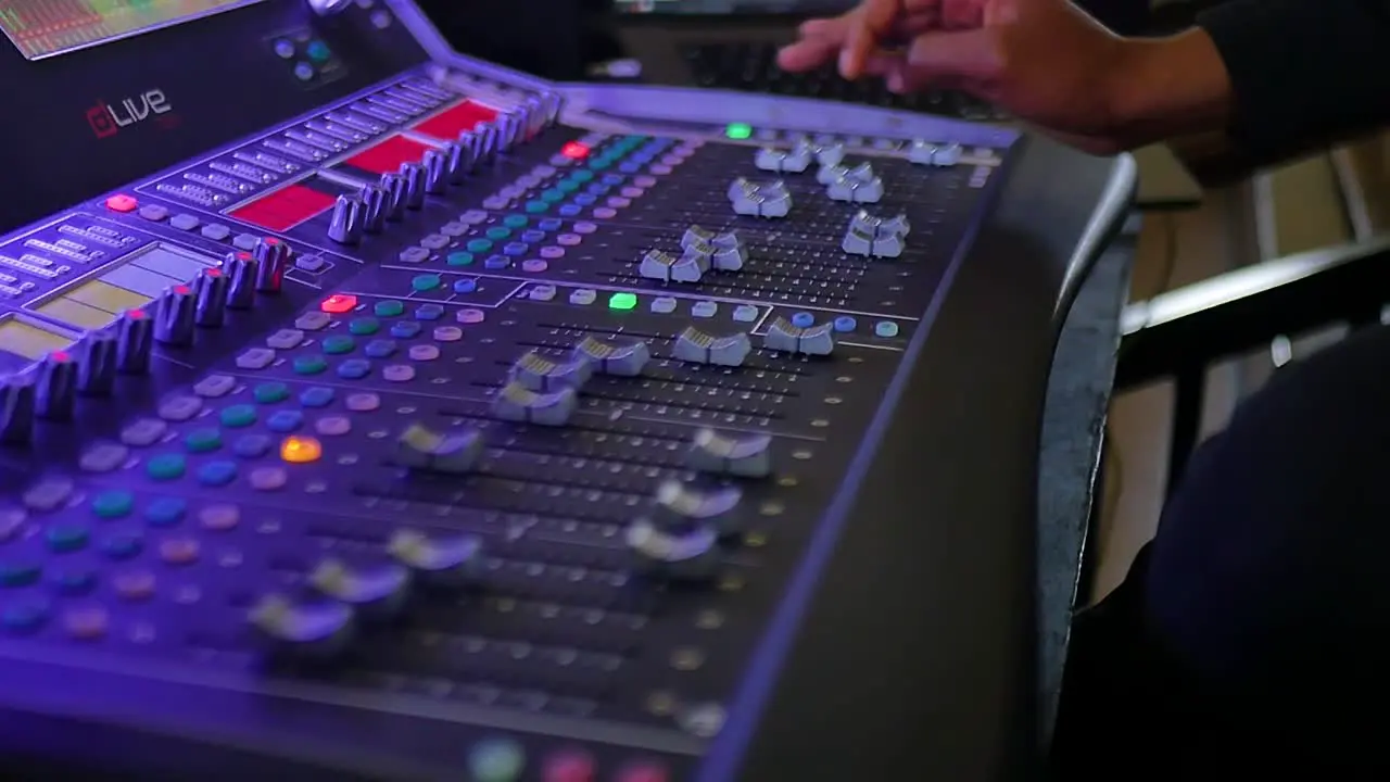 A skilled hand delicately manipulating the controls and buttons on an audio mixer