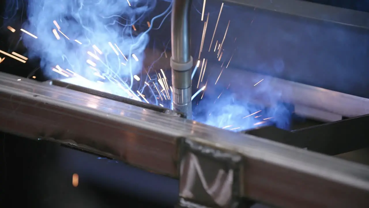 Close up footage of a robotic welder that is working on a steel frame in a factory