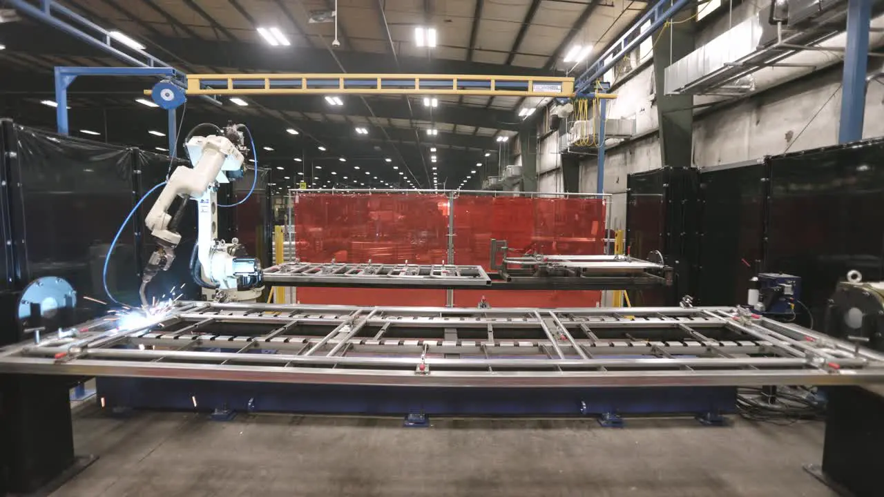 Wide angle timelapse of robotic welder zooming around a project putting in welds on metal