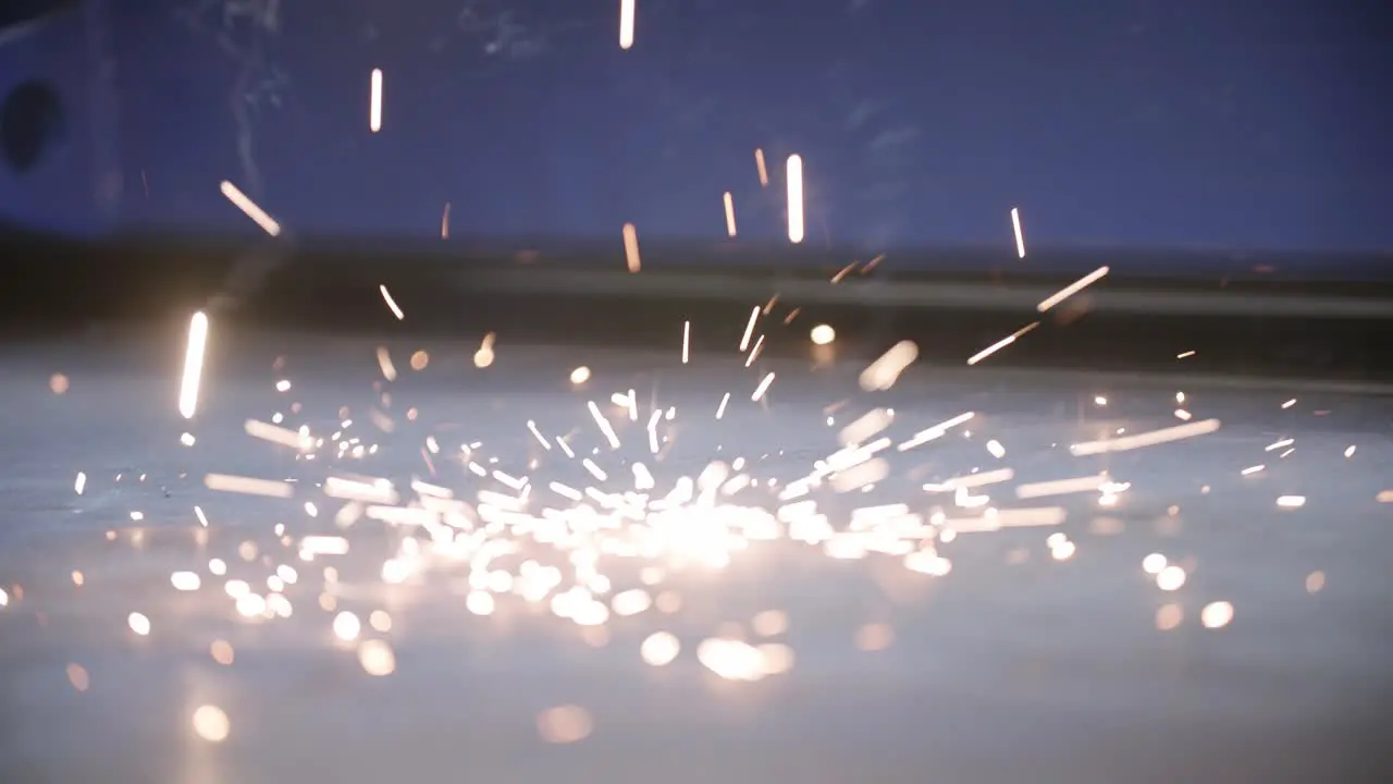 Slow motion of welding sparks hitting the factory floor