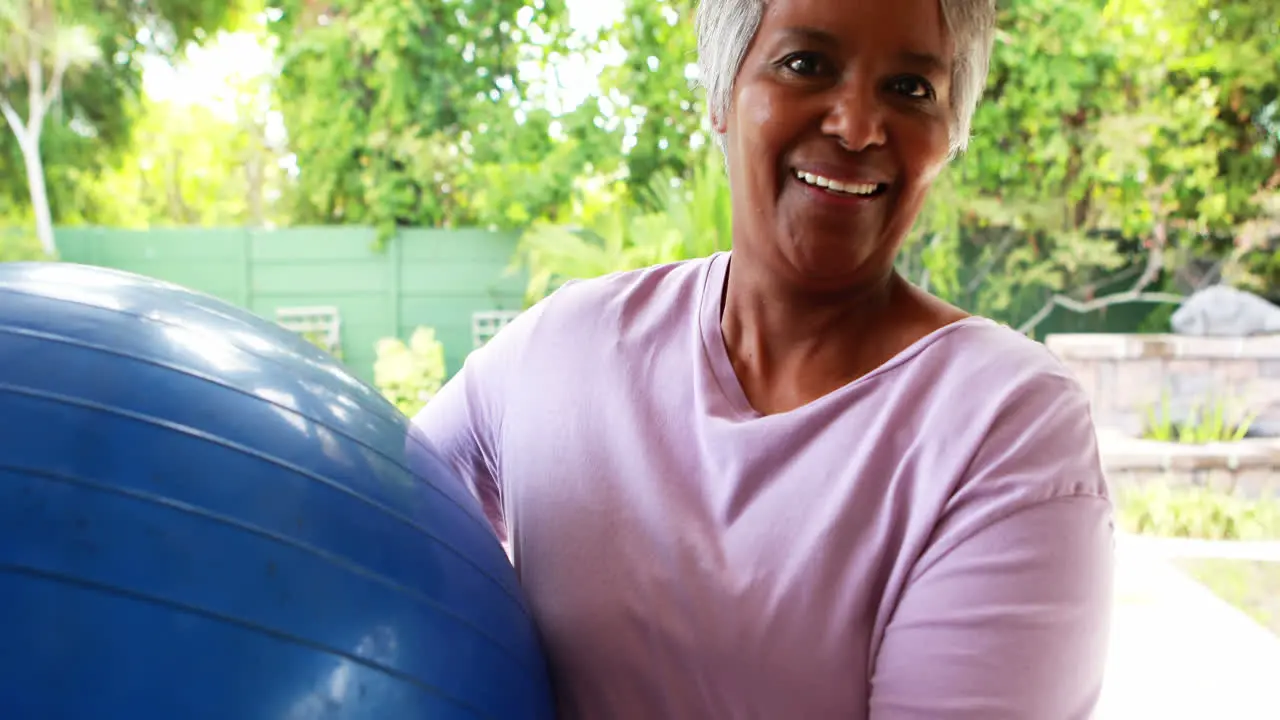 Senior woman holding fitness ball at home