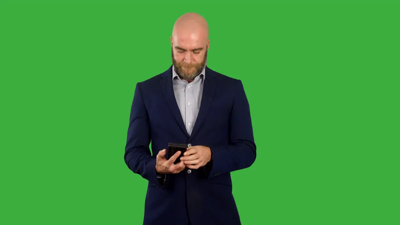 A businessman with beard taking phone out of pocket and using it to text